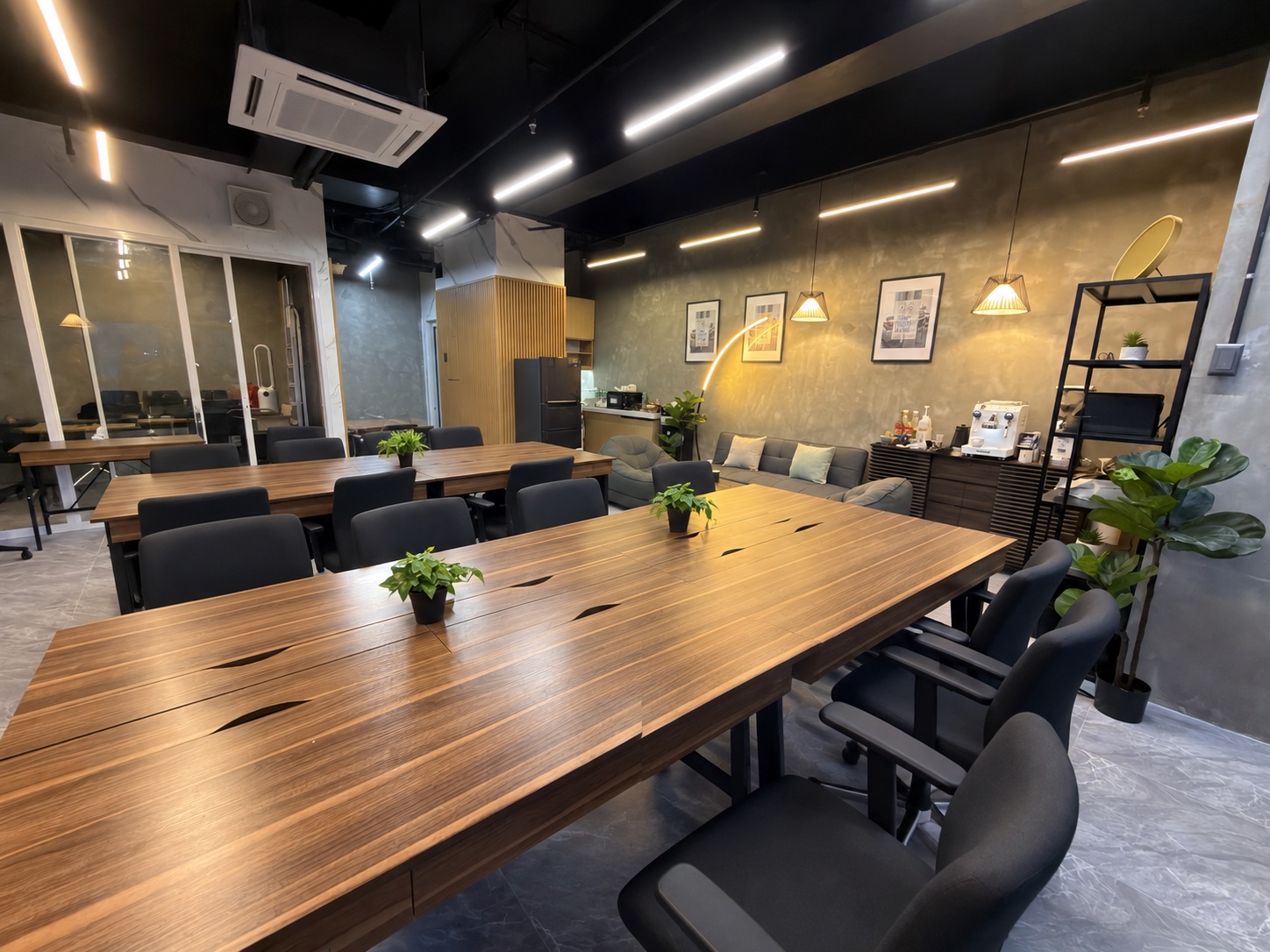 ARC coworking room with wide wooden tables, lounge seating and a coffee bar